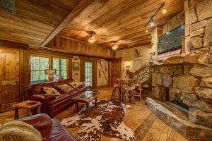 a living room with a couch and a stone fireplace at Winding Log Ridge in Blue Ridge
