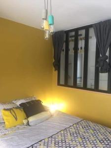 1 dormitorio con 1 cama con pared amarilla en Le jardin de la mer, en Wierre-Effroy