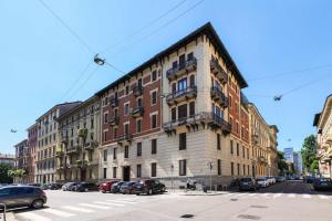 un grand bâtiment dans une rue de la ville avec des voitures garées dans l'établissement Contempora Apartments - Saffi 12, à Milan