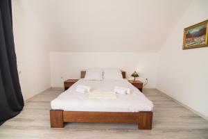 a bedroom with a bed with white sheets at Margit Sziget in Svalyava