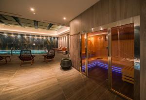 a lobby with a swimming pool and a room with chairs at Catalonia Donosti in Donostia-San Sebastián