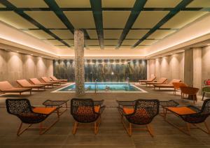 a hotel lobby with a pool and chairs at Catalonia Donosti in Donostia-San Sebastián