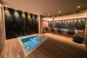 a pool in the middle of a room with chairs at Catalonia Donosti in Donostia-San Sebastián