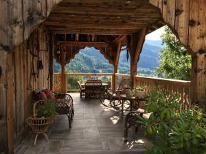 eine Holzterrasse mit einem Tisch und Stühlen darauf in der Unterkunft Atelier des Sapins Blancs (chambre double) in Vacheresse