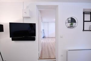 a living room with a flat screen tv on a wall at 2 pièces indépendant dans maison familiale - One bedroom apartment - Family friendly in Vitry-sur-Seine