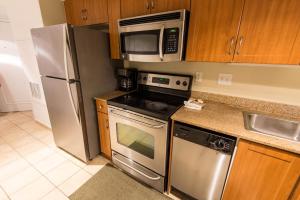 uma cozinha com um frigorífico de aço inoxidável e um micro-ondas em Deluxe Ocean front One Bedroom suite in Sandy Beach Resort em Myrtle Beach