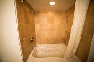 uma banheira na casa de banho com um chuveiro em Deluxe Ocean front One Bedroom suite in Sandy Beach Resort em Myrtle Beach