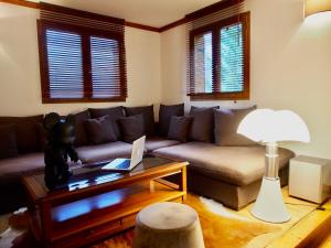 a living room with a couch and a table at Chalet Greystone in Brides-les-Bains