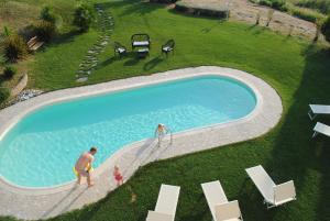 un hombre, una mujer y un niño jugando en una piscina en 5 bedrooms villa with sea view private pool and enclosed garden at Montelabbate, en Montelabbate