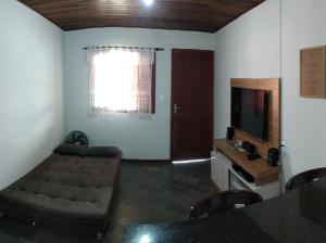 - un salon avec un canapé et une télévision dans l'établissement Recanto Açoriano, à Florianópolis