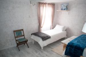 1 dormitorio con 1 cama, 1 silla y 1 ventana en Brakvlei 2, en Albertinia