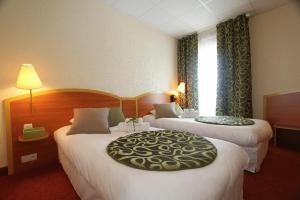 a hotel room with two beds and two lamps at Kyriad Hotel Lamballe in Lamballe