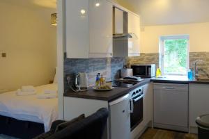 una cucina con lavandino, piano cottura e letto di Derwent View Holiday Apartments a Matlock