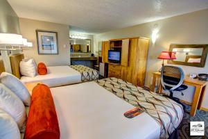 a hotel room with two beds and a tv at Old Town Inn in Florence