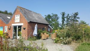 een rood bakstenen huis met een tafel en stoelen bij Villa Selva in Loppersum
