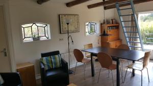 a dining room with a table and chairs and a ladder at Villa Selva in Loppersum
