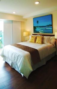 a bedroom with a large bed with yellow pillows at Alameda Cariari Apartments in San José