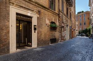 una strada di ciottoli accanto a un edificio di mattoni di Hotel Rinascimento - Gruppo Trevi Hotels a Roma