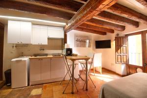 una cocina con armarios blancos y una mesa en una habitación en CuencaLoft Alojamientos Solla, en Cuenca