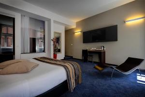 ローマにあるHotel Rinascimento - Gruppo Trevi Hotelsのベッド1台、薄型テレビが備わるホテルルームです。
