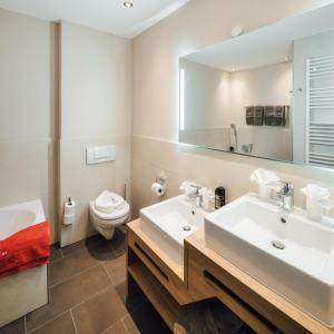 ラディスにあるKinderhotel Laderhofのバスルーム(洗面台、トイレ、鏡付)