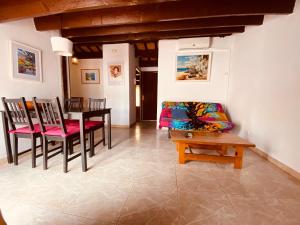 a living room with a table and chairs and a couch at Apartamentos Mitus in Canet de Mar