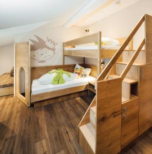 ラディスにあるKinderhotel Laderhofの二段ベッド2組と階段が備わる二段ベッドルーム1室です。