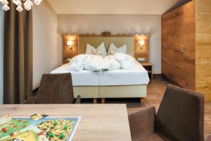 um quarto de hotel com uma cama e uma mesa em Kinderhotel Laderhof em Ladis