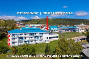 a large white building with a blue roof at Hotel Plante in Gaspé