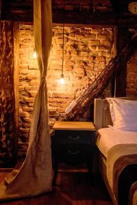 een slaapkamer met een bed en een stenen muur bij Wood House Republicii in Braşov