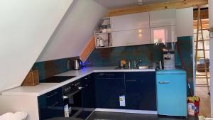 a kitchen with blue cabinets and a blue refrigerator at Gästehaus Kamminke in Kamminke