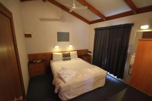 niewielka sypialnia z łóżkiem i oknem w obiekcie Metung Holiday Villas w mieście Metung