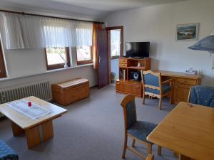 een woonkamer met een tafel en een bureau bij Appartementhaus Looss in Altenau