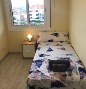 1 dormitorio con cama y ventana en Cerdanyola centro, en Cerdanyola del Vallès