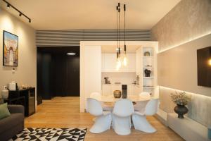 sala de estar con mesa y 2 sillas blancas en FLH Augusta's Arch Sophisticated Flat en Lisboa