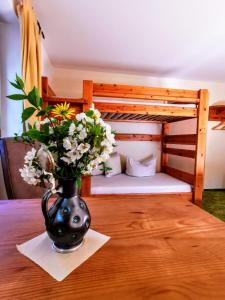 a vase filled with flowers on a wooden table at Ferienwohnung Hegemühle in Geithain