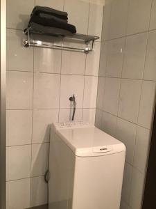 a bathroom with a toilet and a white tiled wall at Bokelrehm 3 in Bokelrehm +13 photos