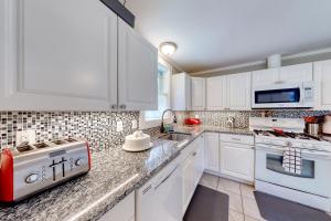 a kitchen with white cabinets and a stove top oven at Acadia Cottage in Bar Harbor