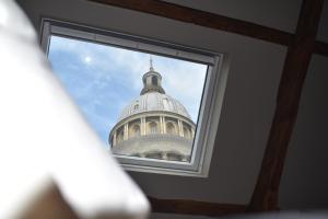 a view of the dome of a building through a window at Maison 1747 - Gîtes de Standing en Vieille-ville avec Cour in Boulogne-sur-Mer