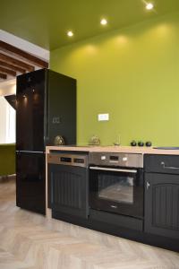 a kitchen with a stove and a refrigerator at Maison 1747 - Gîtes de Standing en Vieille-ville avec Cour in Boulogne-sur-Mer +65 photos