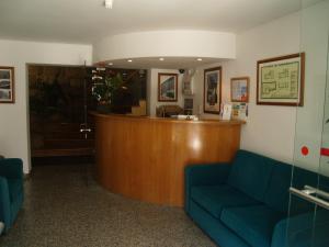 uma sala de espera com um banco e uma recepção em Hotel Santos em Guarda