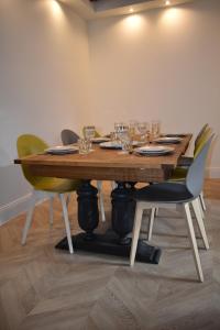 - une table en bois avec des chaises et des verres à vin dans l'établissement Maison 1747 - Gîtes de Standing en Vieille-ville avec Cour, à Boulogne-sur-Mer