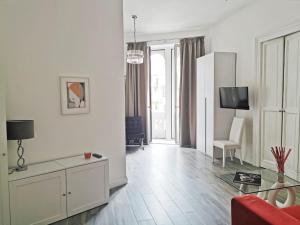 un soggiorno bianco con divano rosso e tavolo di Duomo Platinum Apartments a Napoli
