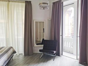 ein Schlafzimmer mit einem schwarzen Stuhl und einem Spiegel in der Unterkunft Duomo Platinum Apartments in Neapel