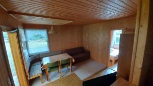 ein kleines Zimmer mit einem Sofa und einem Tisch in der Unterkunft Waldfrieden Bungalow in Garnsdorf