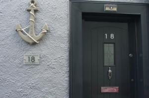 a building with a door with an anchor on it at Anchor cottage in Brixham