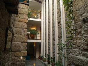 um corredor de um edifício com plantas em Hotel Santos na Guarda