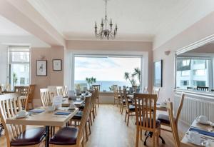 a dining room with a table and chairs and a large window at Anacapri in Falmouth