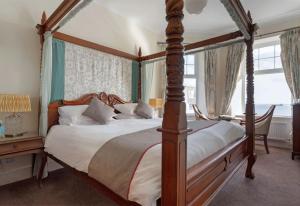 a bedroom with a four poster bed and a desk at Anacapri in Falmouth