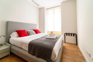 Un dormitorio con una cama grande con almohadas rojas. en Morar Apartments Malasaña, en Madrid